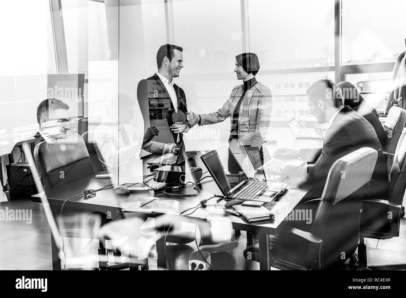La gente di affari si stringono la mano nel moderno ufficio aziendale. Foto Stock