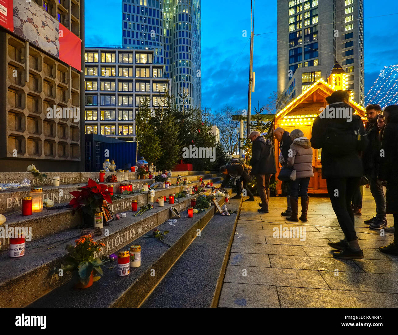 Berlin Breitscheidplatz memorial al Mercato di Natale, Berlin City Weihnachtsmarkt, per la12 vittime del terrore 2016 attacco. Visitatori accendendo candele. Foto Stock