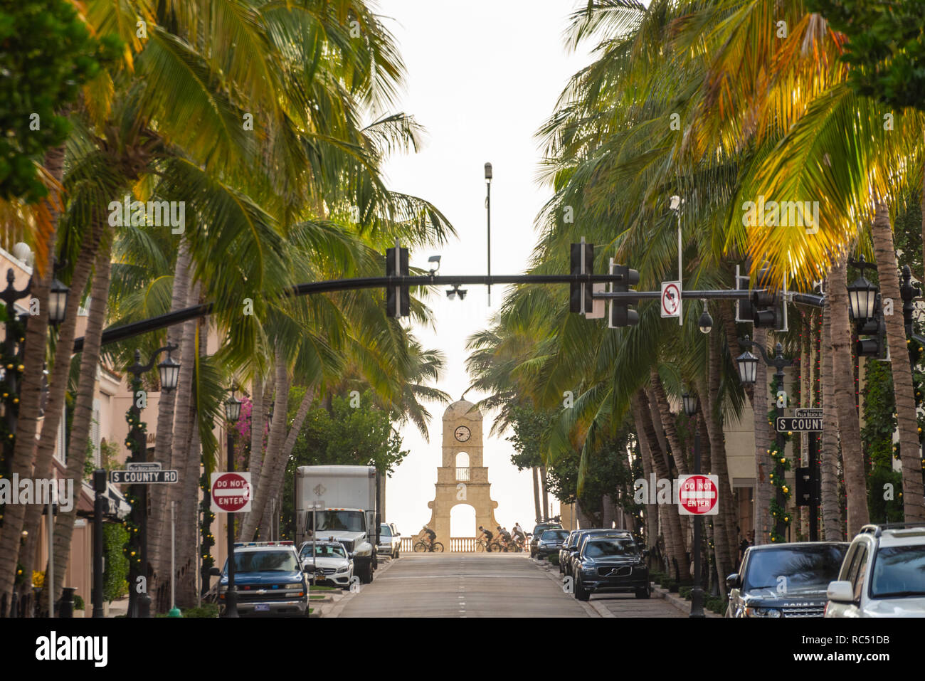 Fiancheggiata da palme Worth Avenue e oceanfront Clock Tower con la mattina presto i ciclisti in Palm Beach, Florida. (USA) Foto Stock