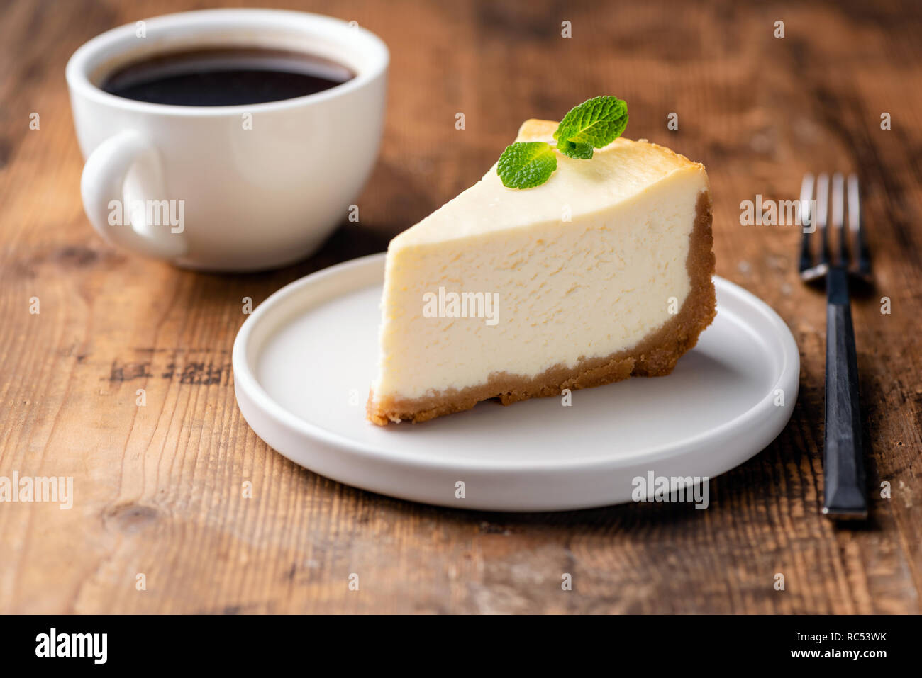 Cheesecake e la tazza di caffè sul tavolo di legno. Caffè e torta. Visualizzazione orizzontale Foto Stock