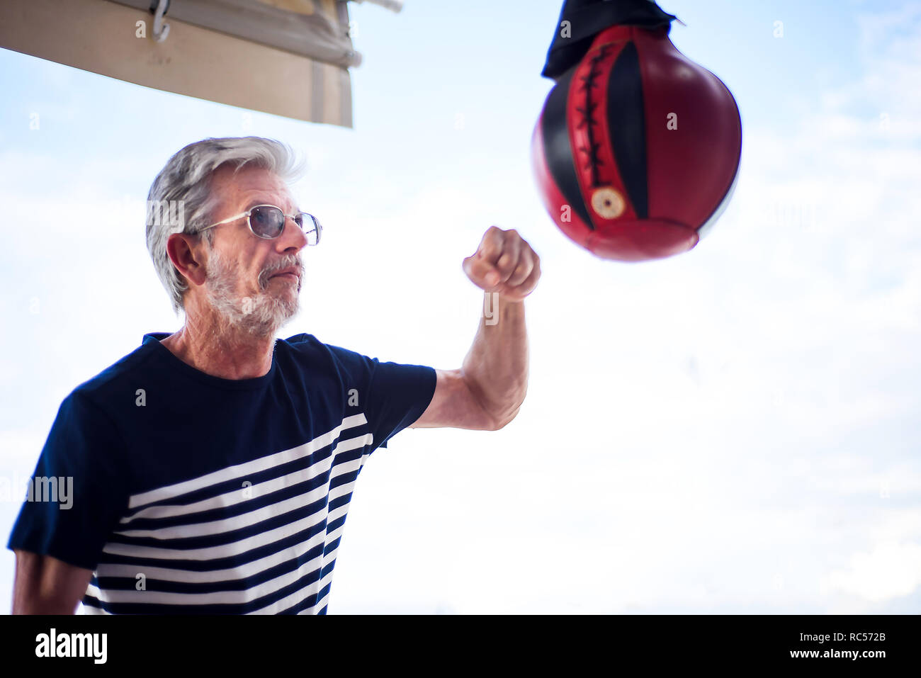 Uomo senior di punzonatura del boxer arcade a carnevale Foto Stock