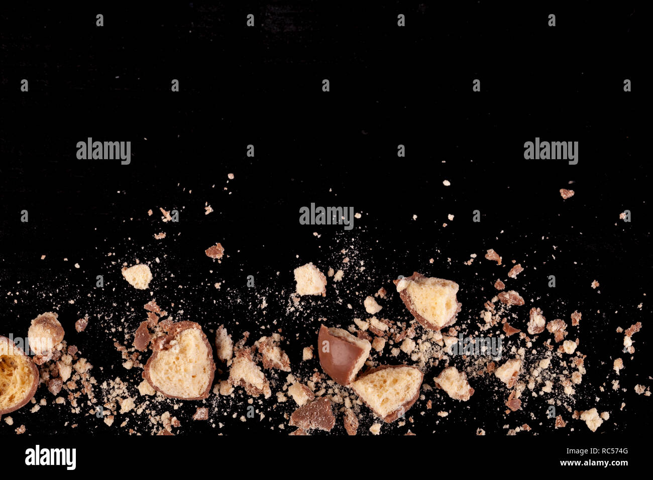 Nido di cioccolato grattugiato con bit e pezzi rotti sul fondo di teh immagine Foto Stock