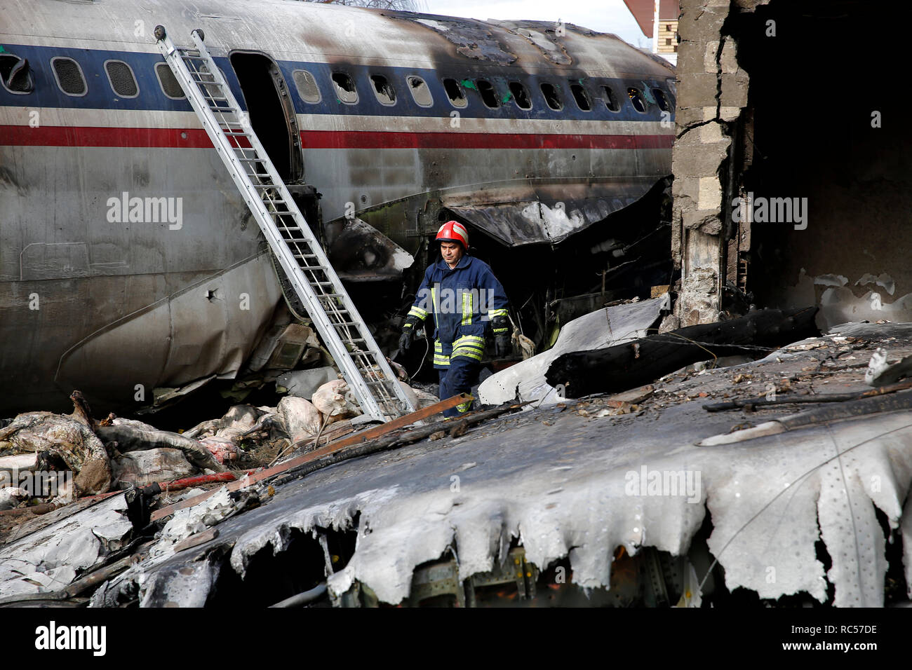Questa foto fornite da Mizan News Agency, mostra un iraniano di opere di soccorso presso il sito di un Boeing 707 cargo aereo crash, a Fath aeroporto circa 40 chilometri (25 miglia) ad ovest di Tehran, Iran, lunedì, 14 gennaio 2019. Il governo iraniano di emergenza ufficiali di gestione ha raccontato la tv di stato che 16 persone erano a bordo di un Boeing 707 cargo aereo che si è schiantato a ovest di Teheran e che ci è noto un unico superstite. (Hasan Shirvani/Mizan News Agency via AP) Foto Stock