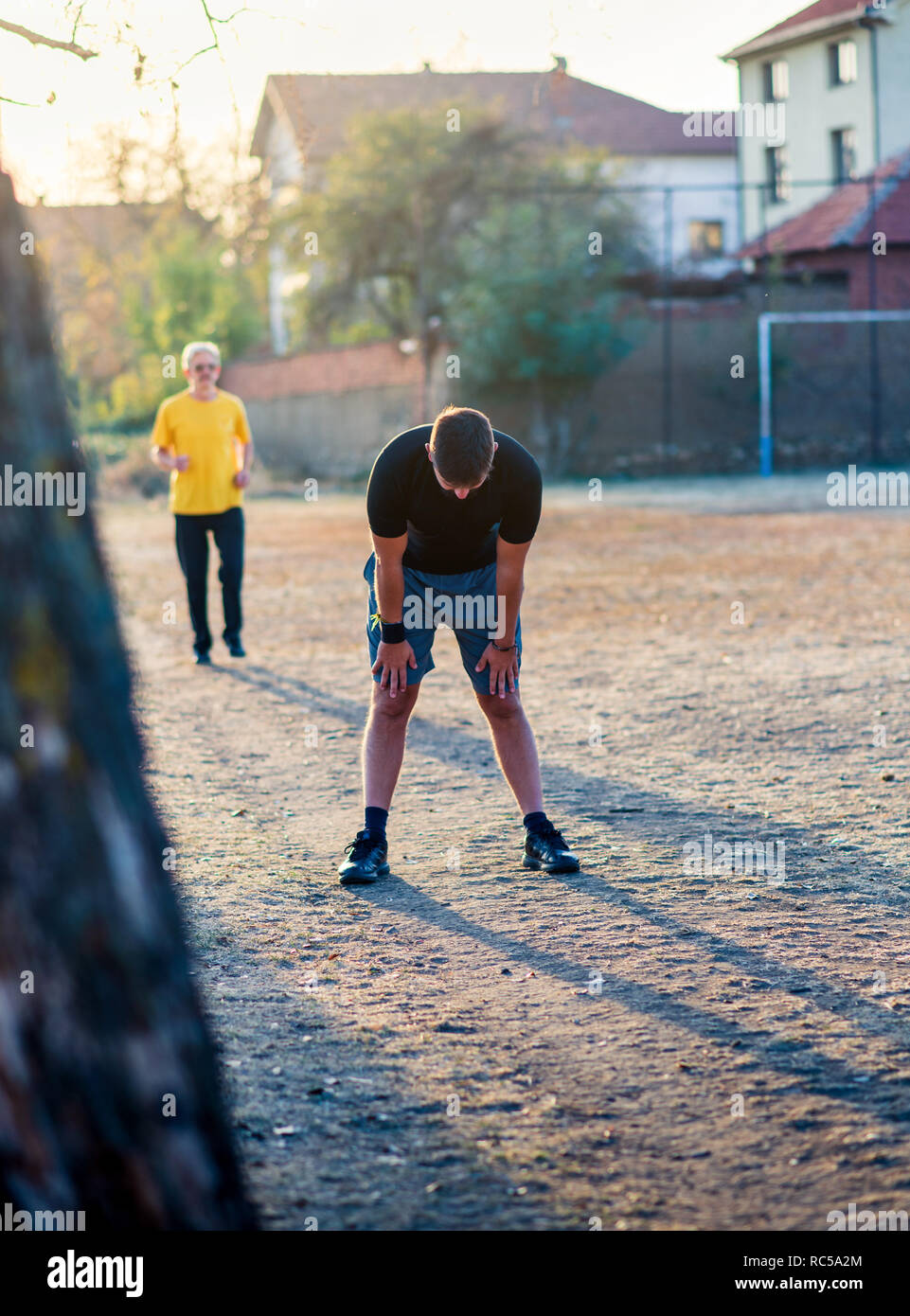 Gli uomini tenendo il resto durante la corsa nel parco Foto Stock