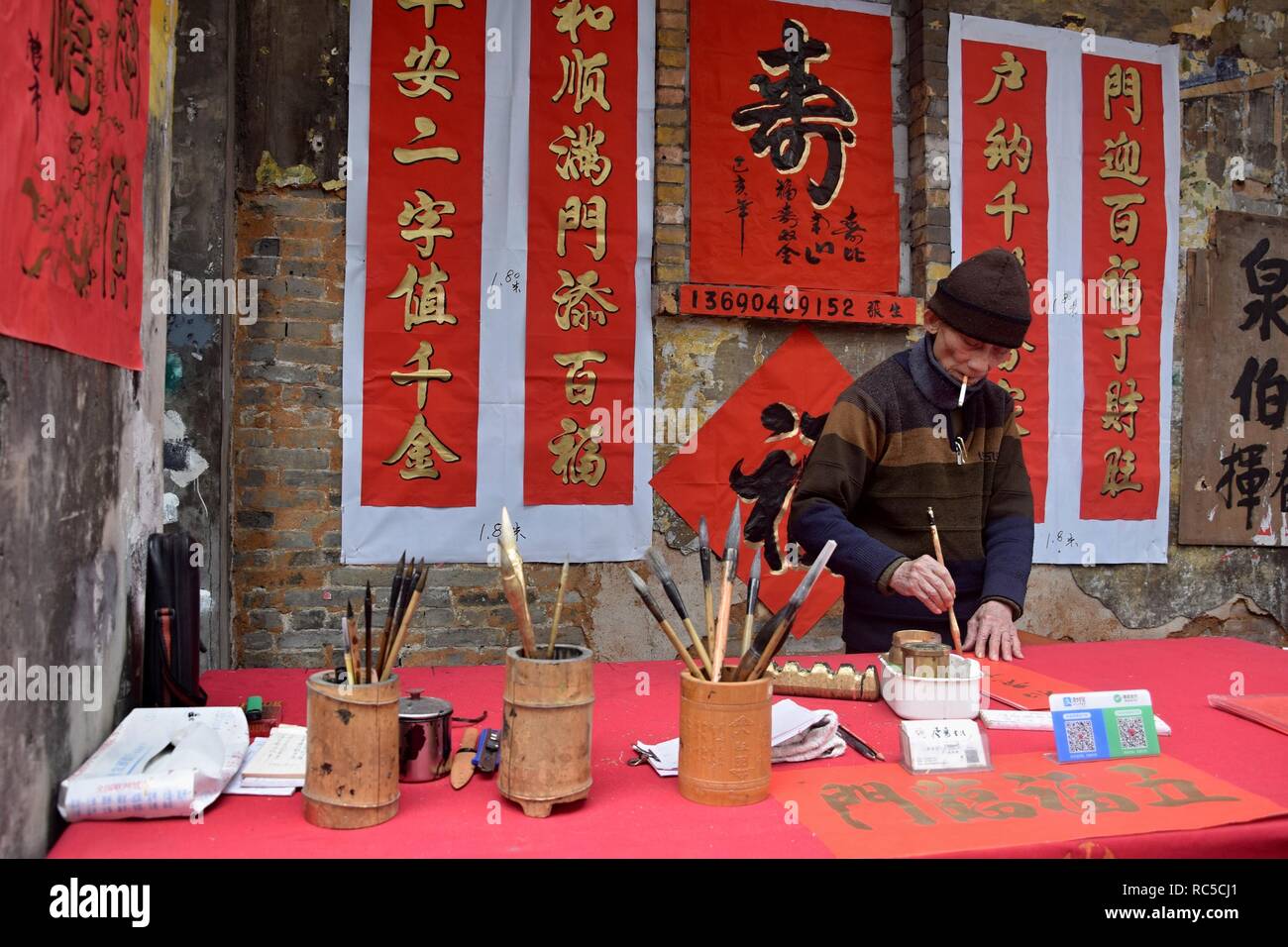 FOSHAN, Cina - circa gennaio 2019: Un vecchio uomo benedizione di scrittura baciata in occasione del festival di primavera. Foto Stock