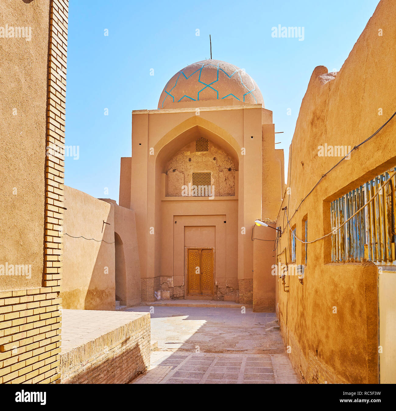 Adobe Costruzione di Madraseh-e Kamalieh con alti iwan (portale) e scenic dome, decorata con azure stelle di piastrelle, Yazd, Iran. Foto Stock