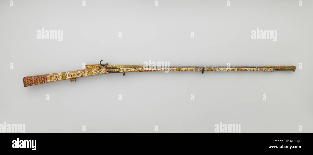 Pistola Matchlock. Cultura: Indiano, Rajasthan o di Lahore. Dimensioni: L. 61 5/8 in. (156,4 cm); L. della canna 42 7/8 in. (108,8 cm); Cal. .44 in. (11,0 mm); Wt. 8 lb. (3631 g). Data: tardo XVIII-XIX secolo. Le armi da fuoco sono stati utilizzati in India a partire dal XV secolo e la matchlock è rimasto il preferito meccanismo di armi da fuoco fino a circa 1830. Questa pistola sportiva si distingue per il suo delicato dipinto di magazzino coperto con scene di caccia, uccelli e altri animali e paesaggi. L'oro-damascened canna è un capolavoro di fucinatura, aventi entrambi una sezione trasversale quadrata e un foro quadrato. È Foto Stock