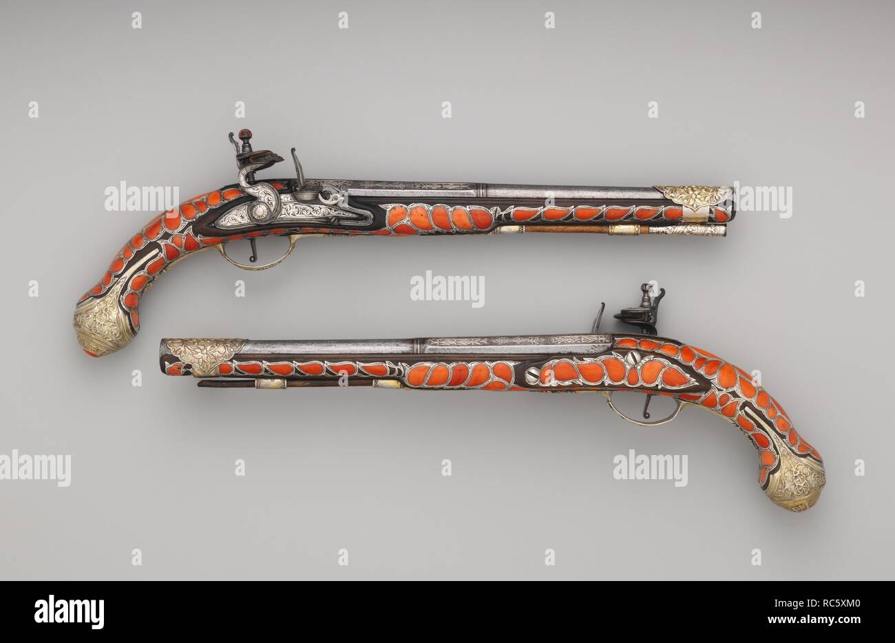 Coppia di Flintlock Pistols. Cultura: algerina. Dimensioni: 36.25.2246a; L. 19 a. (48,3 cm); L. della canna 12 7/8 in. (32,7 cm); Cal. .65 in (16,5 mm); Wt. 3 lb. 0.9 oz. 1386.3 (g); 36.25.2246b; L. 19 a. (48,3 cm); L. della canna 12 13/16 in. (32,5 cm); Cal. 0,64 in (16,3 mm); Wt. 3 lb. 0.5 oz. (1375 g). Data: tardo XVIII-XIX secolo. Pistole simili sono state incluse nel dono di armi presentata dalla dey di Algeri al Principe Reggente (il futuro Giorgio IV di Gran Bretagna) nel 1811 e 1819, a testimonianza della grande stima che questi coral-decorate le armi da fuoco sono stati detenuti. Museo: Metropolitan Foto Stock