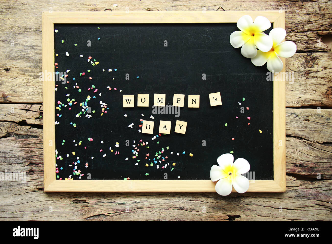 Giornata della donna concetto. testo giornata della donna dal blocco di legno sulla lavagna, decorare con fiore Foto Stock