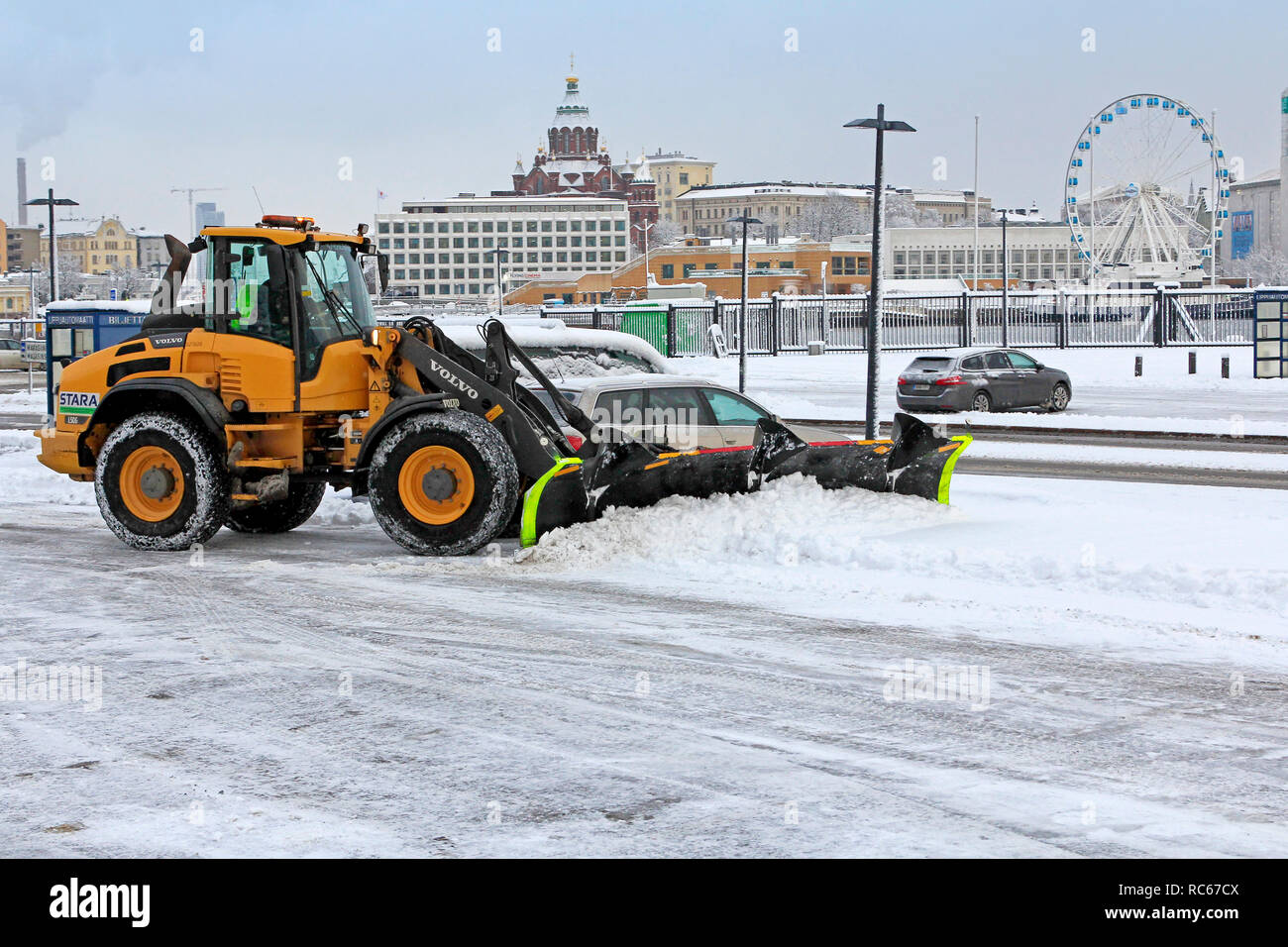 Helsinki, Finlandia - 9 Gennaio 2019: rimozione della neve con Volvo L50G pala caricatrice gommata compatta dotata di spartineve a Helsinki in un giorno d'inverno. Foto Stock