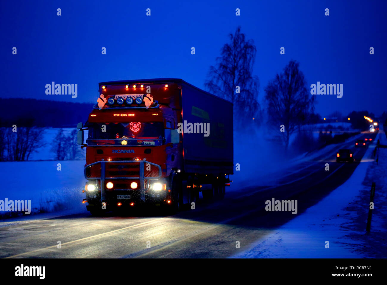 Salo, Finlandia - 21 dicembre 2018: splendidamente personalizzato Scania rosso semi rimorchio di VR Rantanen trasporta il carico sulla autostrada su un blu sera d'inverno. Foto Stock