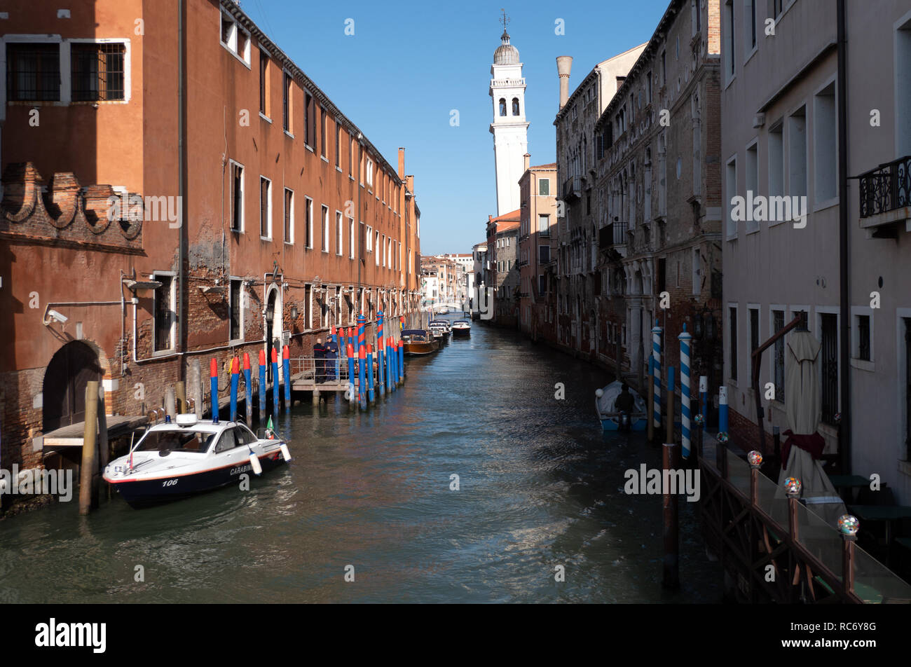 Vista di Venezia, Italia, città con edifici vecchi, barche, canale d'acqua. Viaggi e paesaggio urbano italiano in Venezia, Italia con Carabinieri barca su c Foto Stock
