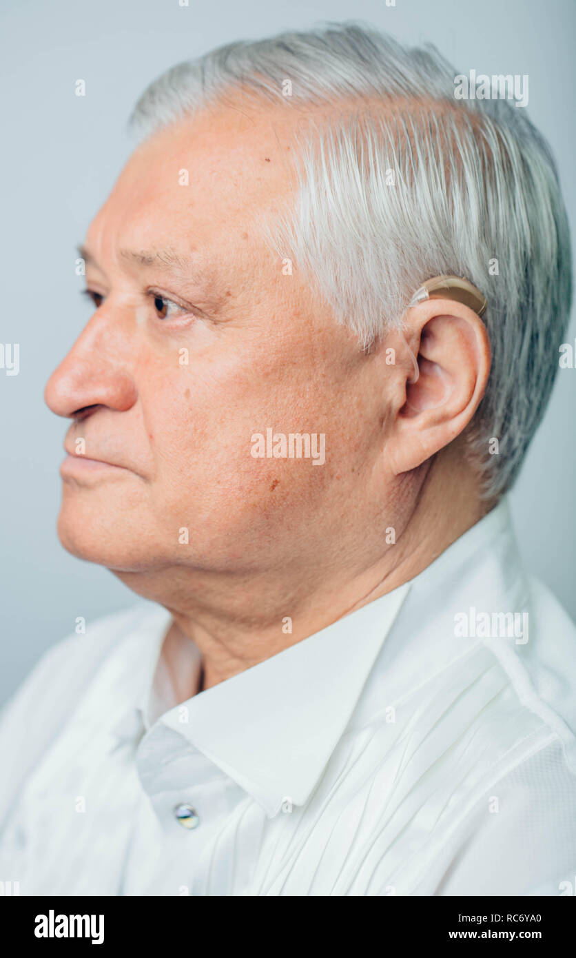 Ritratto di età compresa tra uomo con apparecchi acustici sull'orecchio, orecchio close-up Foto Stock