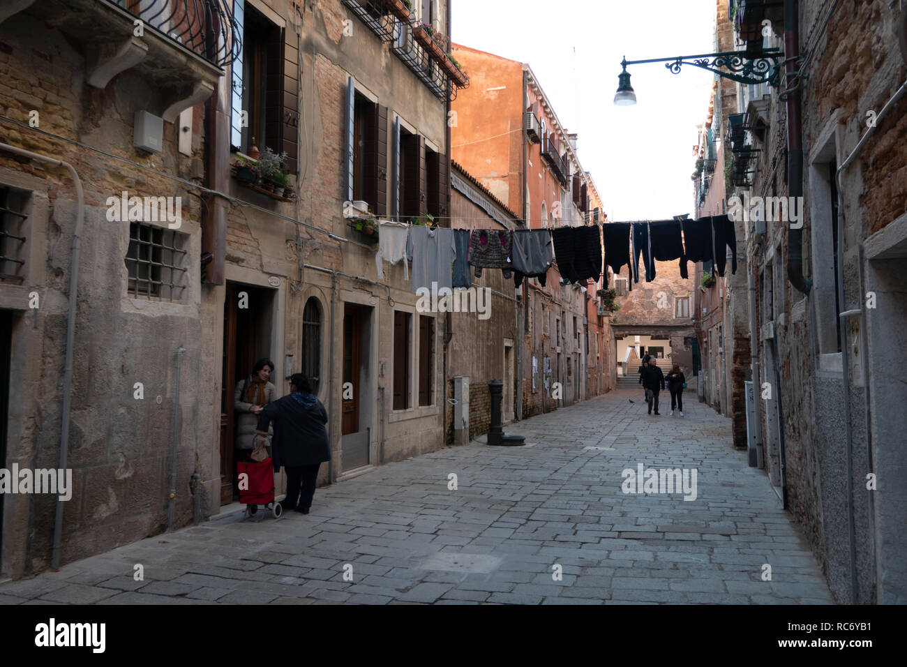 Vista della Corte Nova a Venezia, Italia. La vita quotidiana in Venezia, Italia con donne Italiane di parlare e le vecchie case Foto Stock