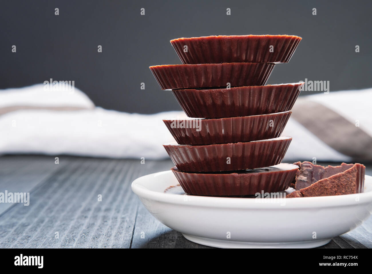 Fatto a mano lo stack di cioccolato bianco sulla piastra in ceramica su legno scuro orizzontale di sfondo con spazio di copia Foto Stock