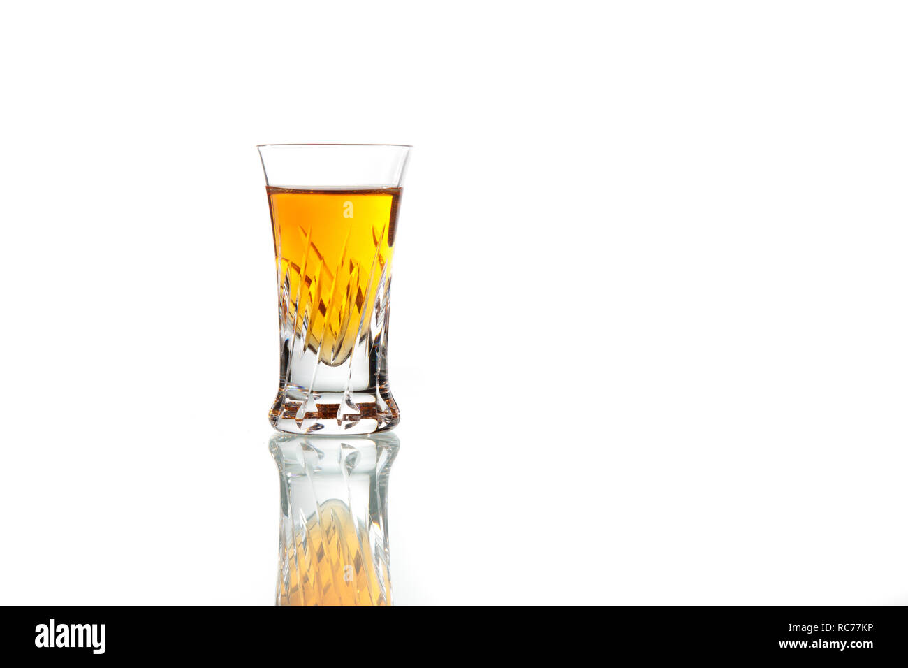 Crystal shot bicchiere di whiskey su sfondo bianco Foto Stock