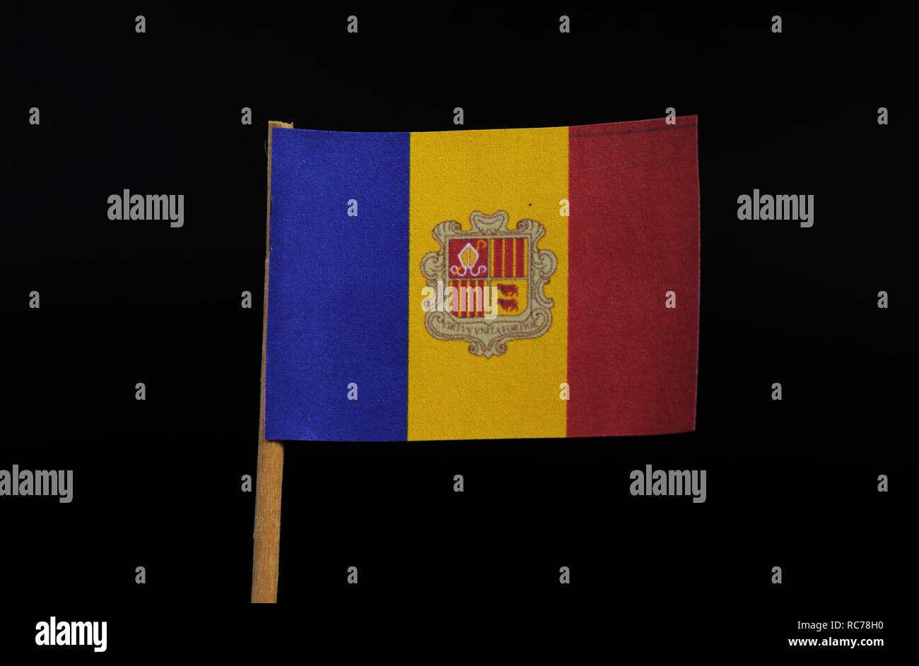 Un ufficiale e bandiera nazionale del Principato di Andorra su stuzzicadenti su sfondo nero. Un tricolore verticale di blu, giallo e rosso con il Na Foto Stock