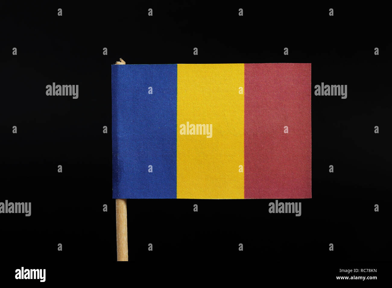 Una bandiera nazionale della Romania su stuzzicadenti su sfondo nero. Un tricolore verticale di blu, giallo e rosso. Foto Stock