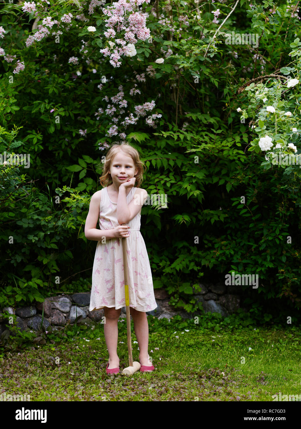 Ragazza con il croquet mallet guardando lontano Foto Stock