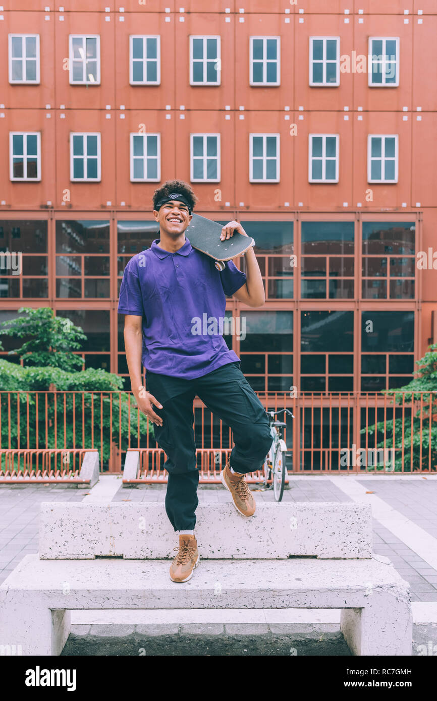 Guidatore di skateboard in posa con lo skateboard, Milano, Italia Foto Stock