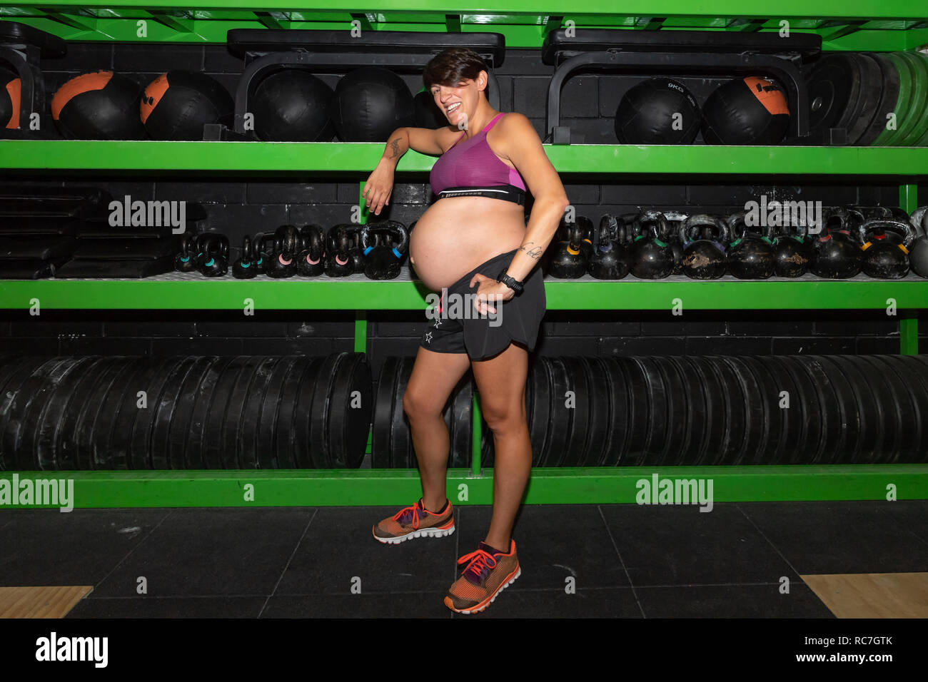 Donna incinta in piedi in palestra Foto Stock