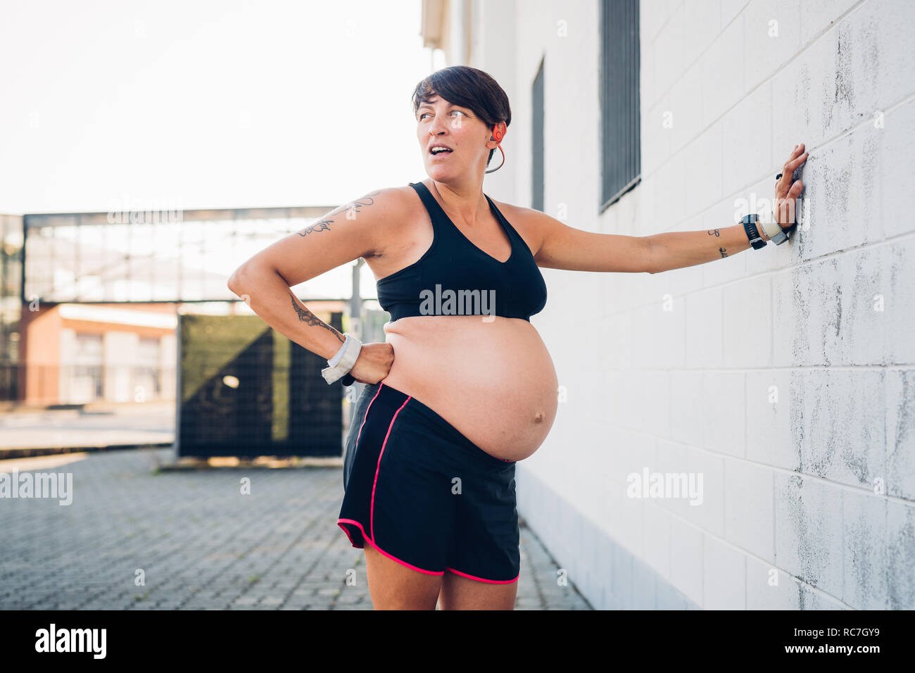 Donna incinta prendendo break da allenamento Foto Stock
