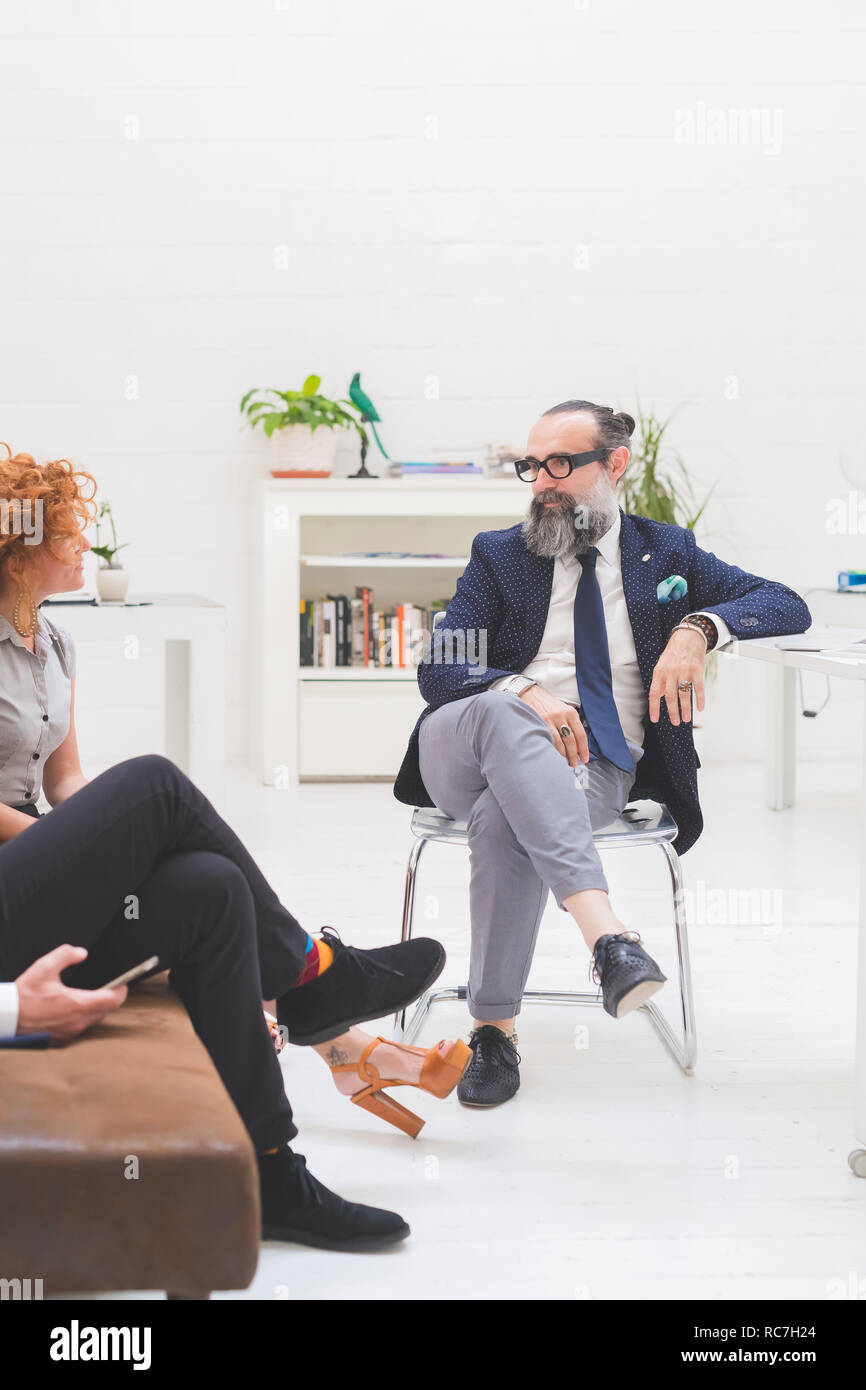 Imprenditori e donna con discussione alla riunione sul divano per ufficio, ritagliato Foto Stock