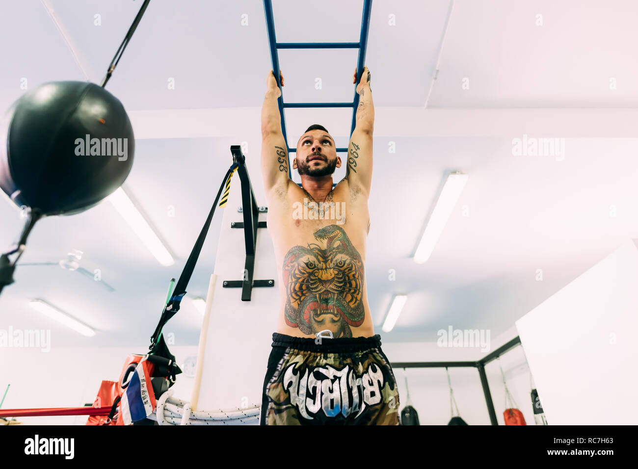 L'uomo oscillare lungo il Monkey Bar Palestra Foto Stock