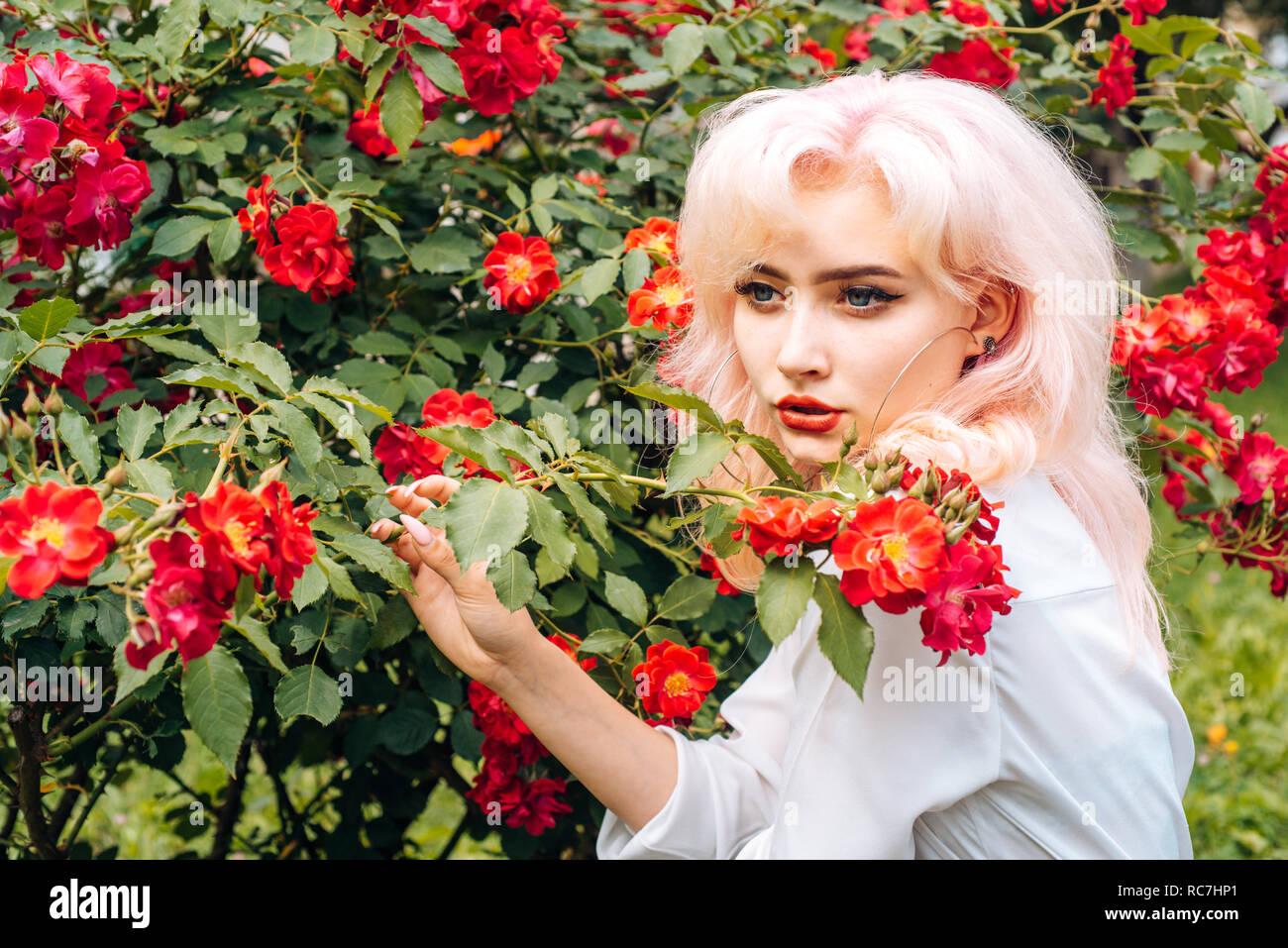 Ragazza con estate trucco. La molla Donna con fiori. Estate bellezza. Prodotti cosmetici per il trucco e la cura della pelle. Moda ritratto di donna. La colorazione dei capelli. Express positività Foto Stock