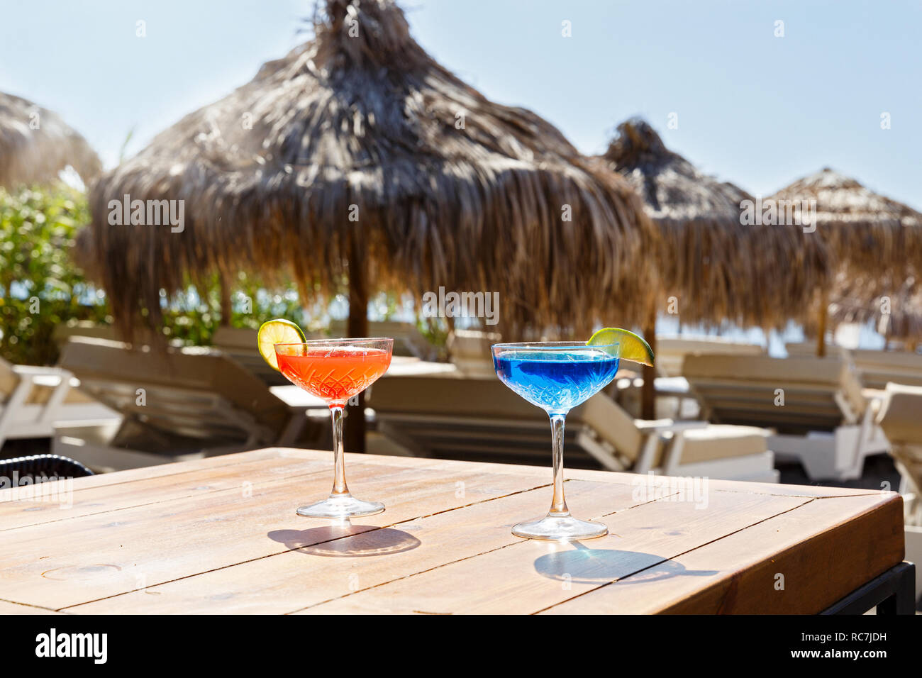 Blu e pink drink sulla spiaggia tabella, contro il mare Foto Stock