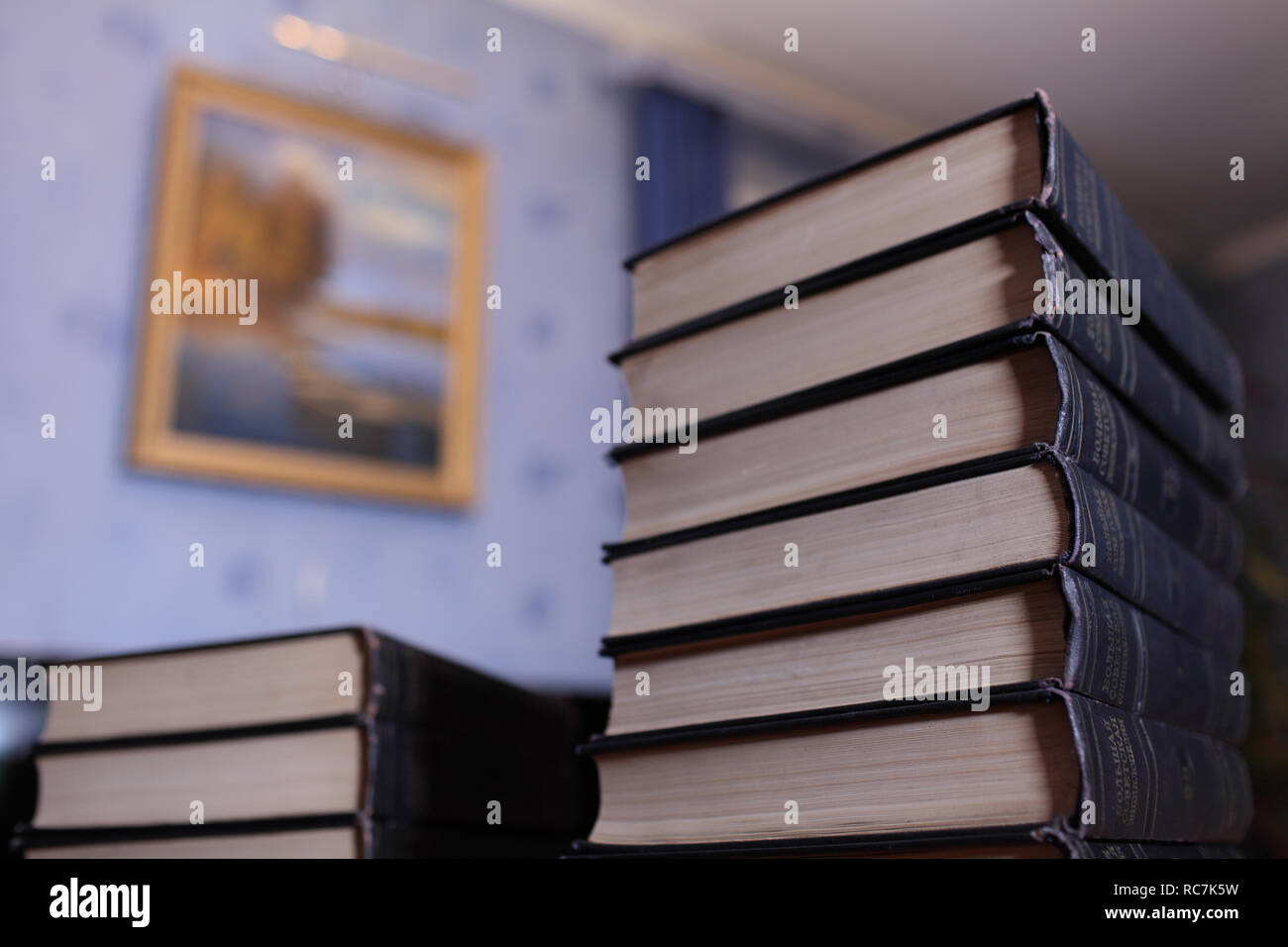 Alta pila di libri sulla scrivania in biblioteca concetto di conoscenza e saggezza Foto Stock