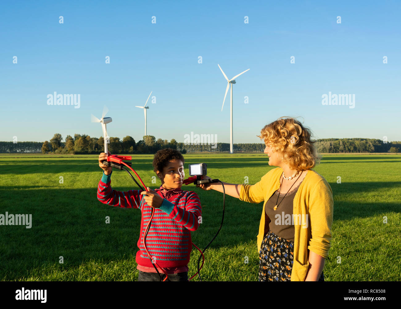 Ragazzo adolescente e una ragazza a sperimentare con l'energia sostenibile da turbine eoliche, Paesi Bassi Foto Stock