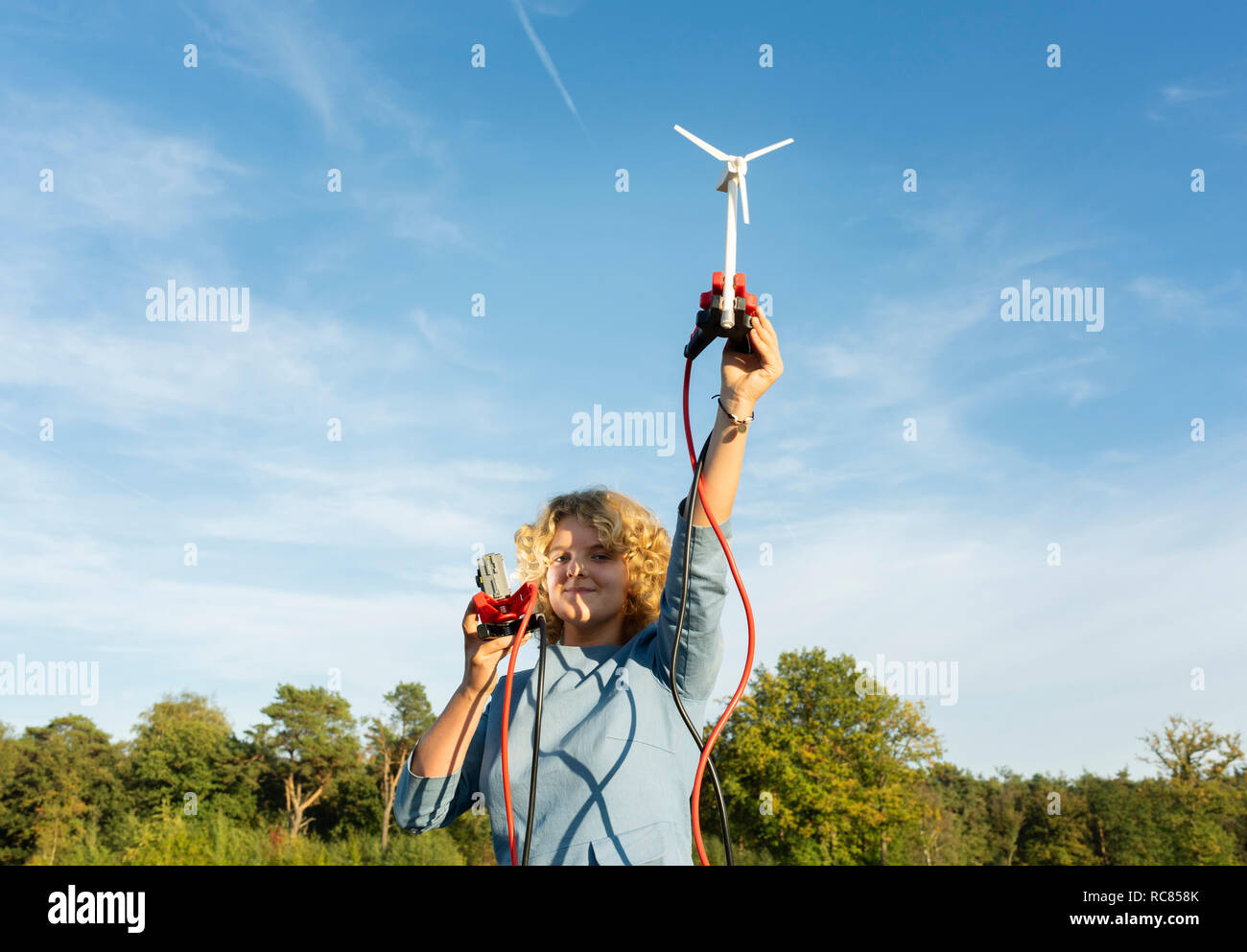 Ragazza adolescente alimentazione luce LED in miniatura con turbina a vento, Paesi Bassi Foto Stock