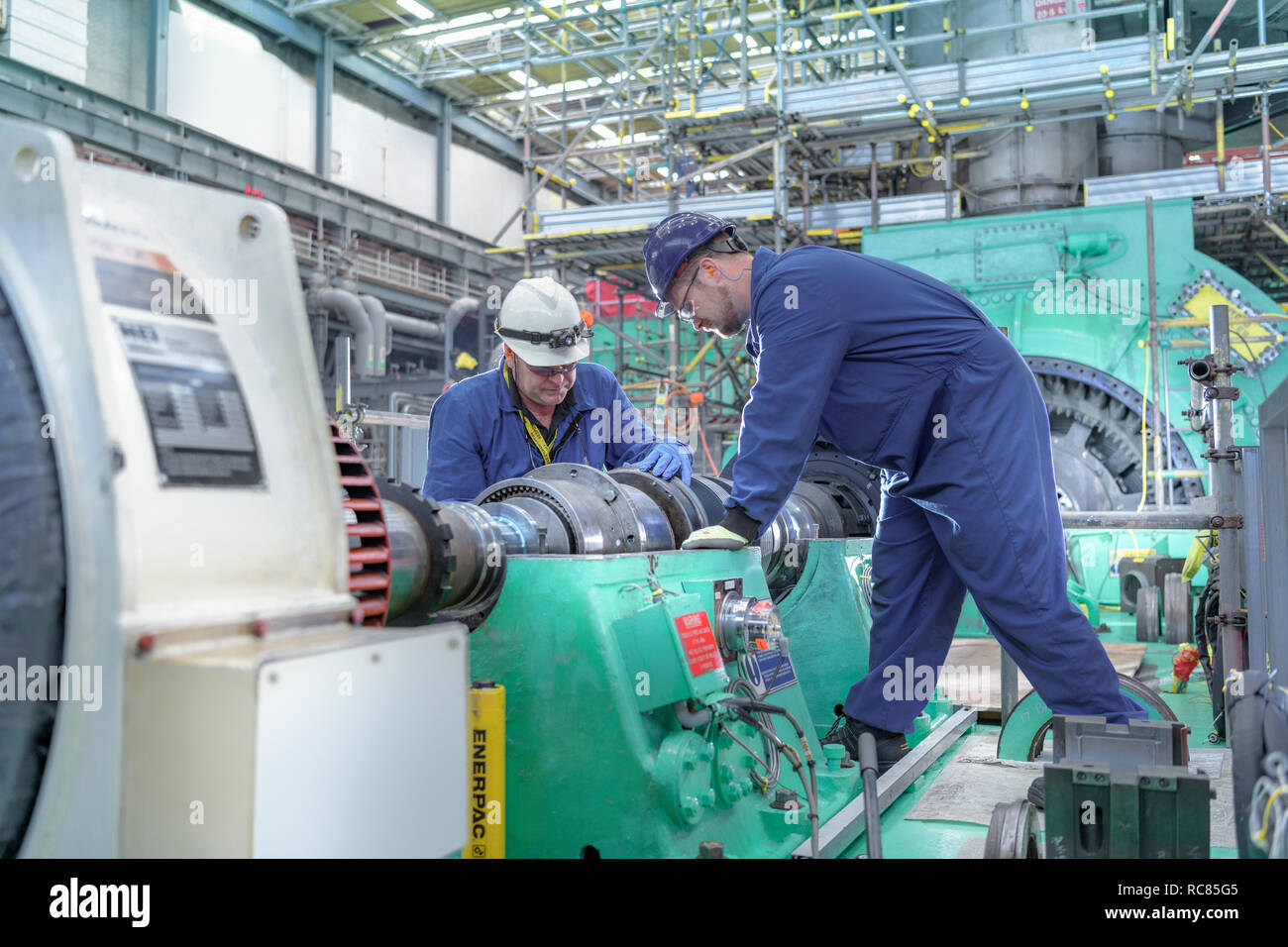Ingegneri di ispezionare gli ingranaggi in corrispondenza di estremità del generatore nella centrale nucleare in caso di interruzioni Foto Stock