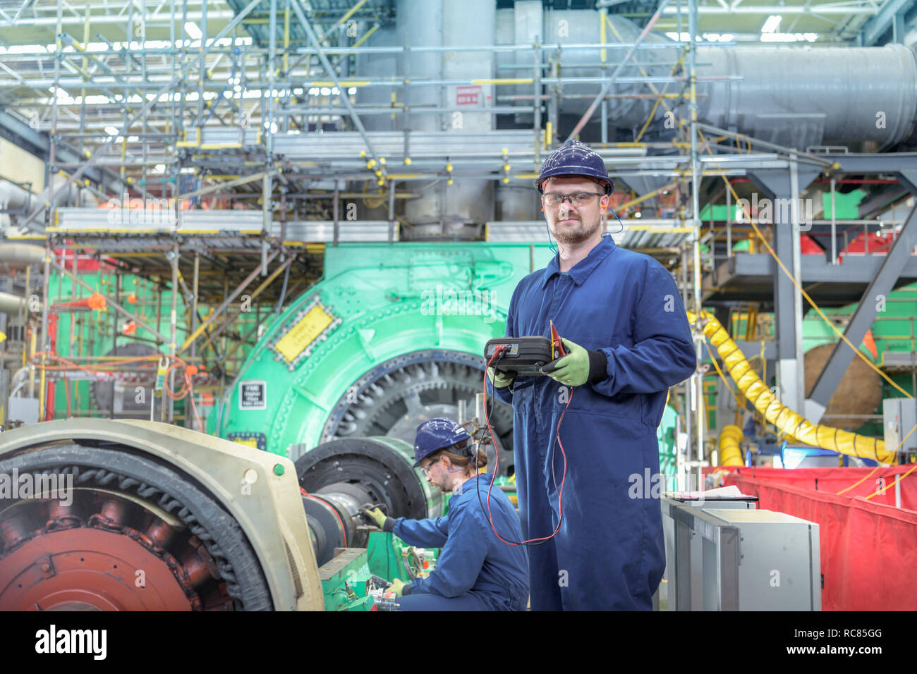 Ritratto di ingegnere in sala della turbina della centrale nucleare in caso di interruzioni Foto Stock