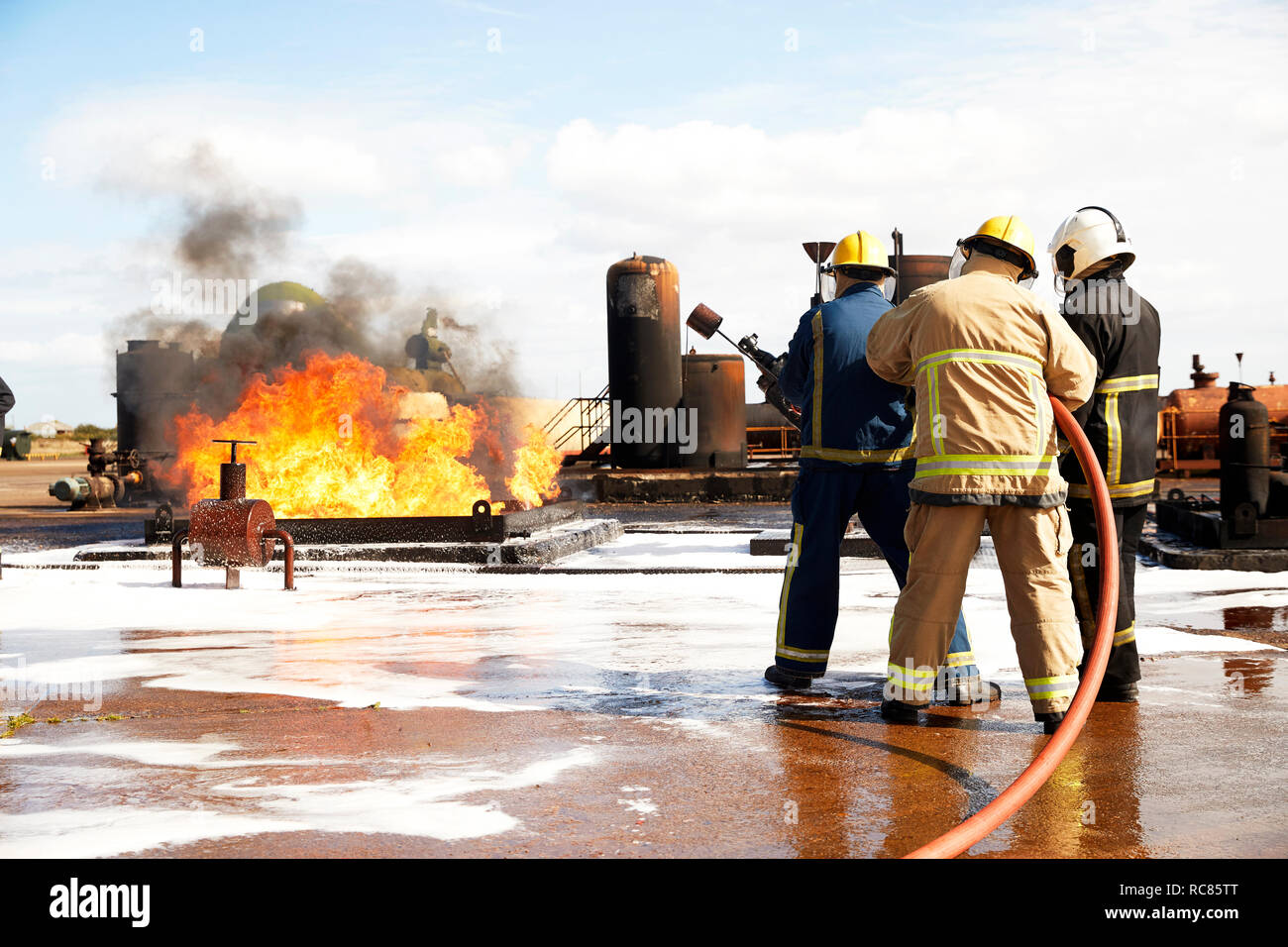 Addestramento vigili del fuoco, i vigili del fuoco si prepara a mettere fuori serbatoio di accumulo di olio a fuoco training facility Foto Stock