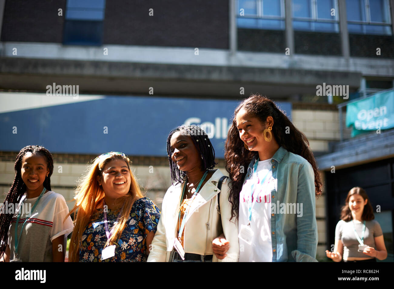 Ragazza adolescente con giovani femmine studenti universitari lasciando college campus Foto Stock