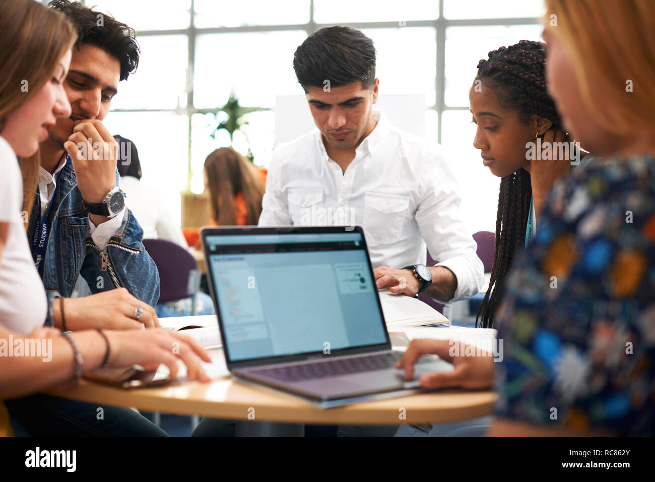Maschi e femmine di istruzione superiore agli studenti di lavorare in team e utilizzando laptop in college classroom Foto Stock