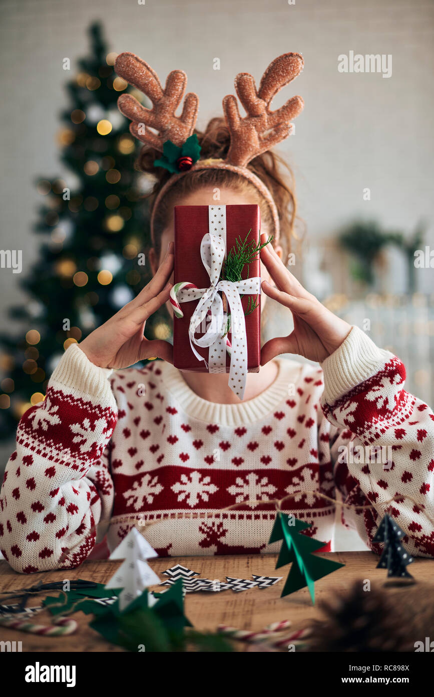 La donna dietro il regalo di Natale, di alberi di Natale decorazioni sagomato in primo piano Foto Stock
