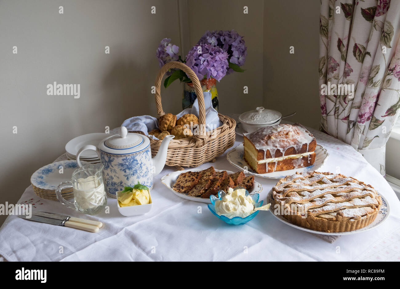 In casa tradizionale tè del pomeriggio con scones, teiera, brack, limone drizzle cake Foto Stock