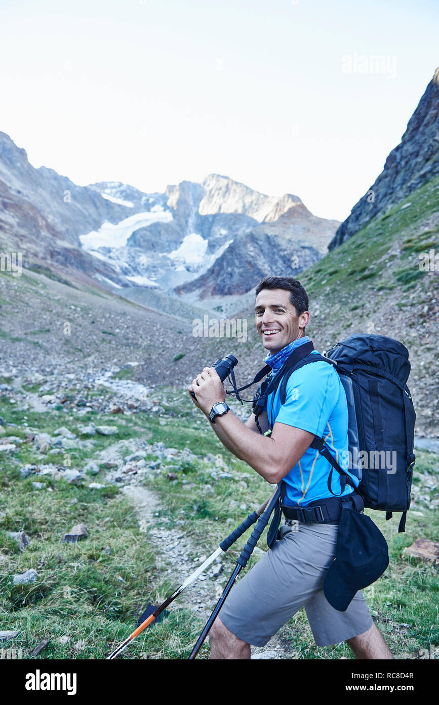 Escursionista utilizzando un binocolo, Mont Cervin, Cervino, Vallese, Svizzera Foto Stock