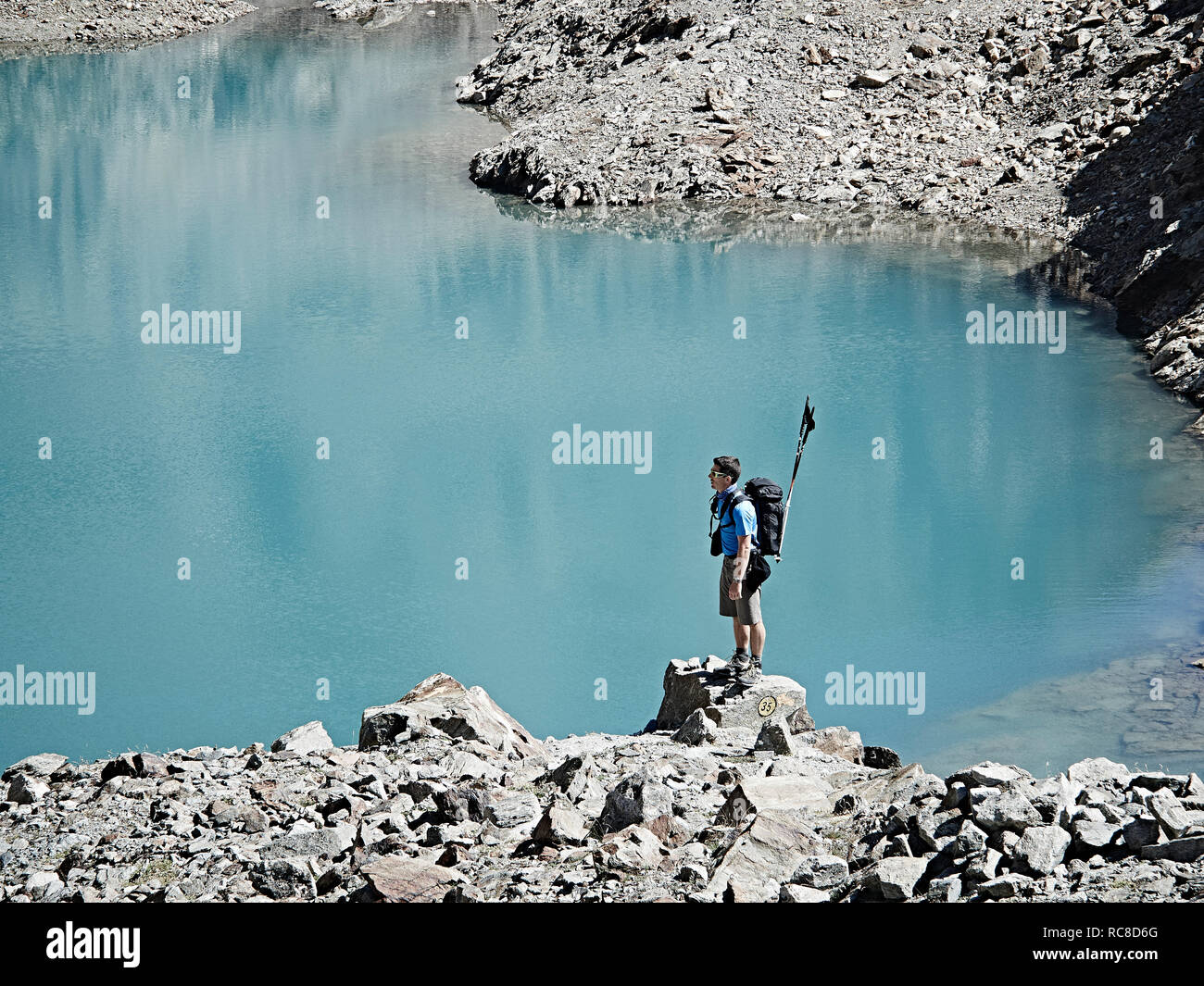 Escursionista sulla roccia dal bordo del lago, Mont Cervin, Cervino, Vallese, Svizzera Foto Stock