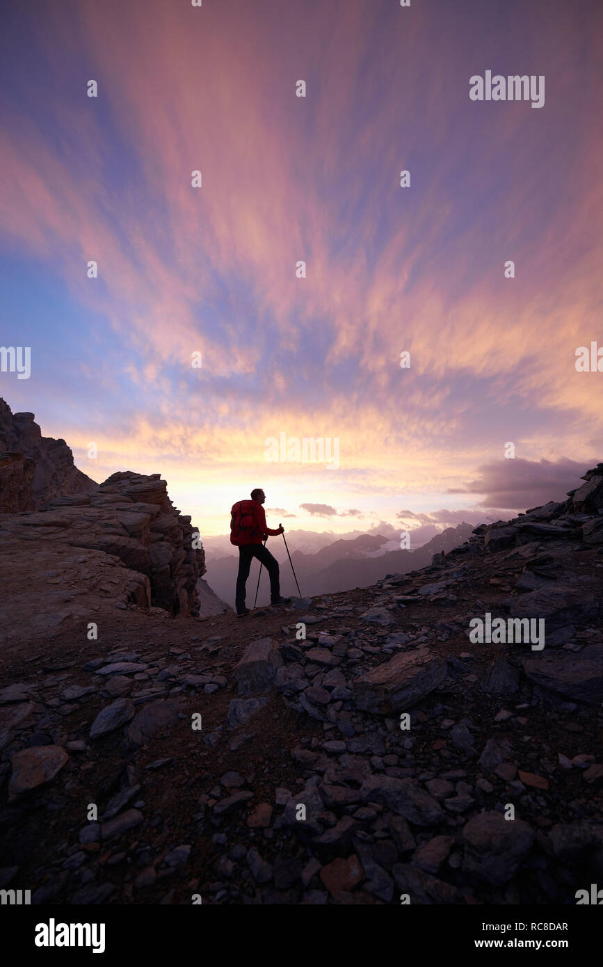 Escursionista ammirando il tramonto, Mont Cervin, Cervino, Vallese, Svizzera Foto Stock