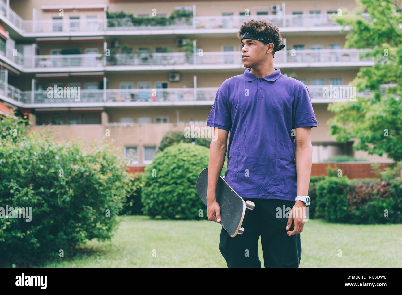 Guidatore di skateboard in posa con lo skateboard, Milano, Italia Foto Stock