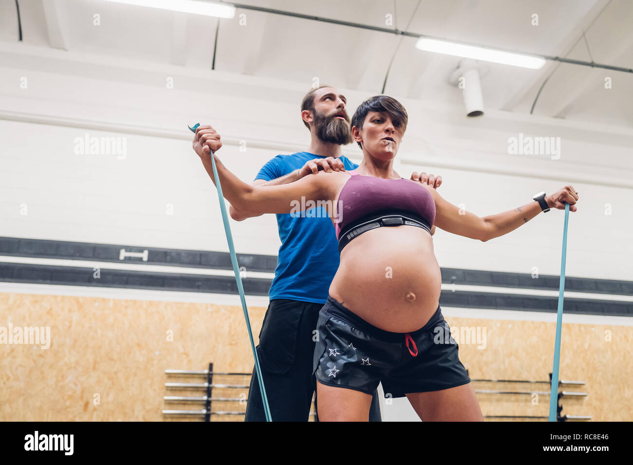 Guida Trainer donna incinta utilizzando corde in palestra Foto Stock