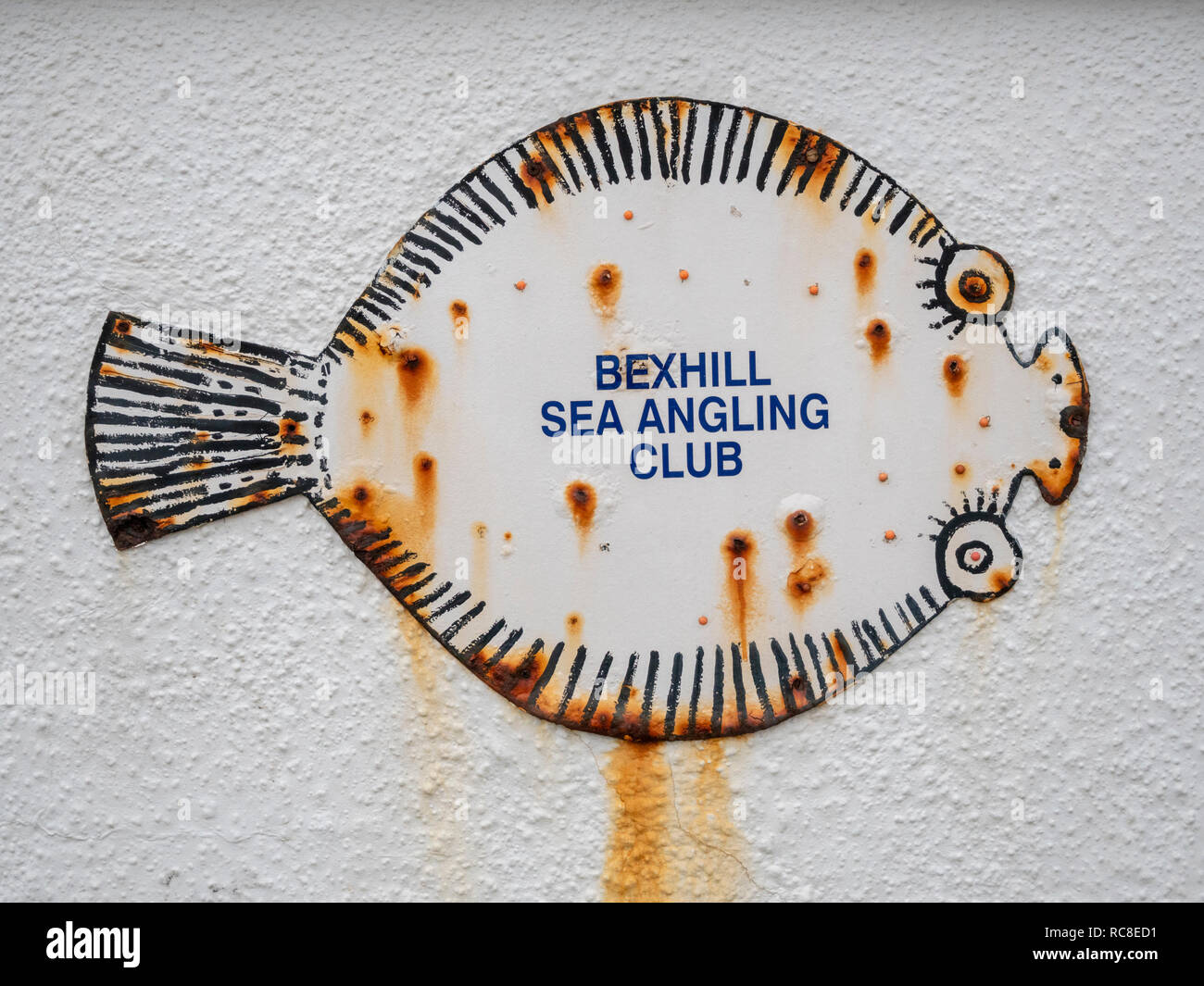 Un segno a forma di pesce su un muro a Bexhill Sea Angling Club Bexhill East Sussex Regno Unito Foto Stock