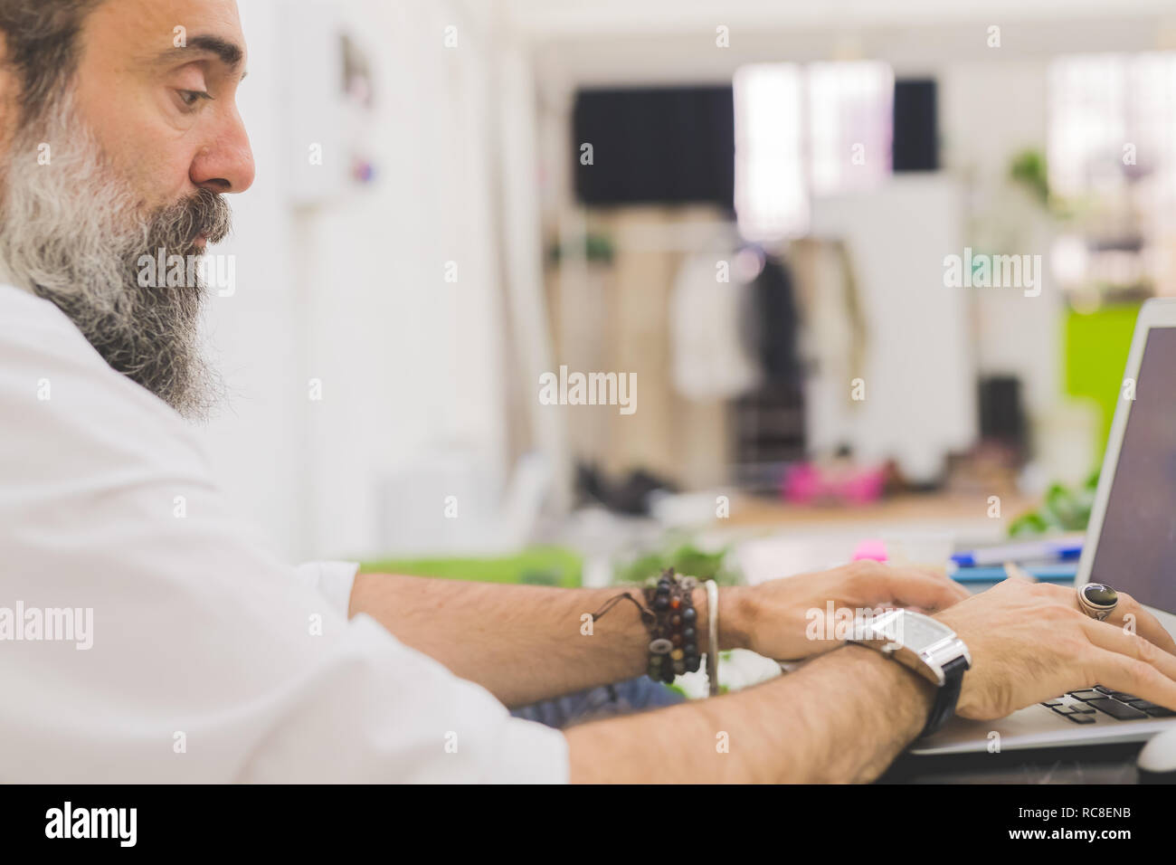 Imprenditore digitando su laptop alla scrivania in ufficio, ritagliato Foto Stock