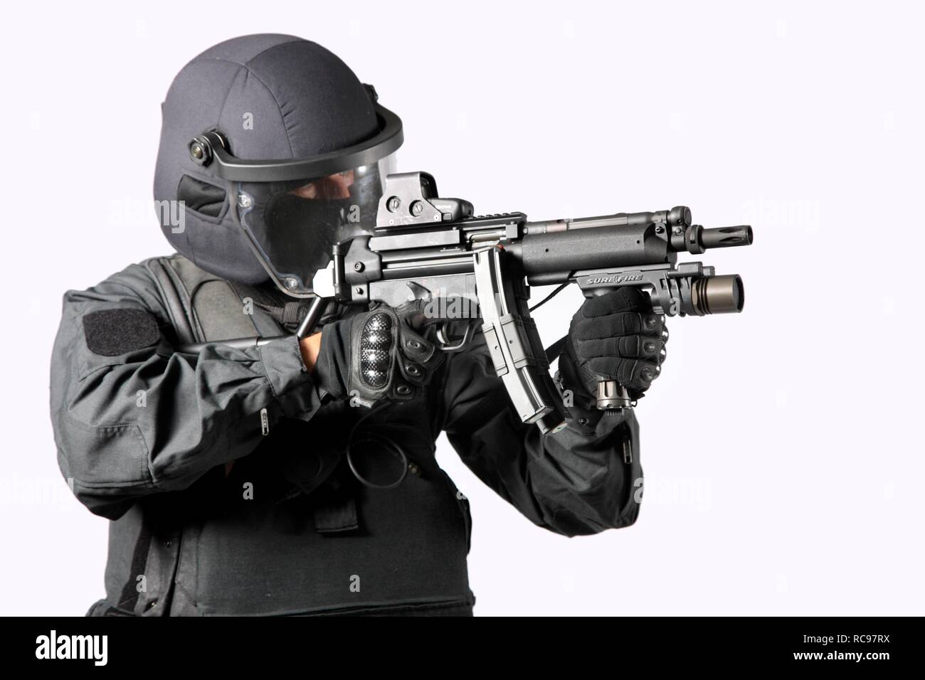 Polizia, Task Force speciale, SEK, officer indossando pieno uniforme di protezione tenendo un Heckler & Koch MP5 mitragliatore Foto Stock