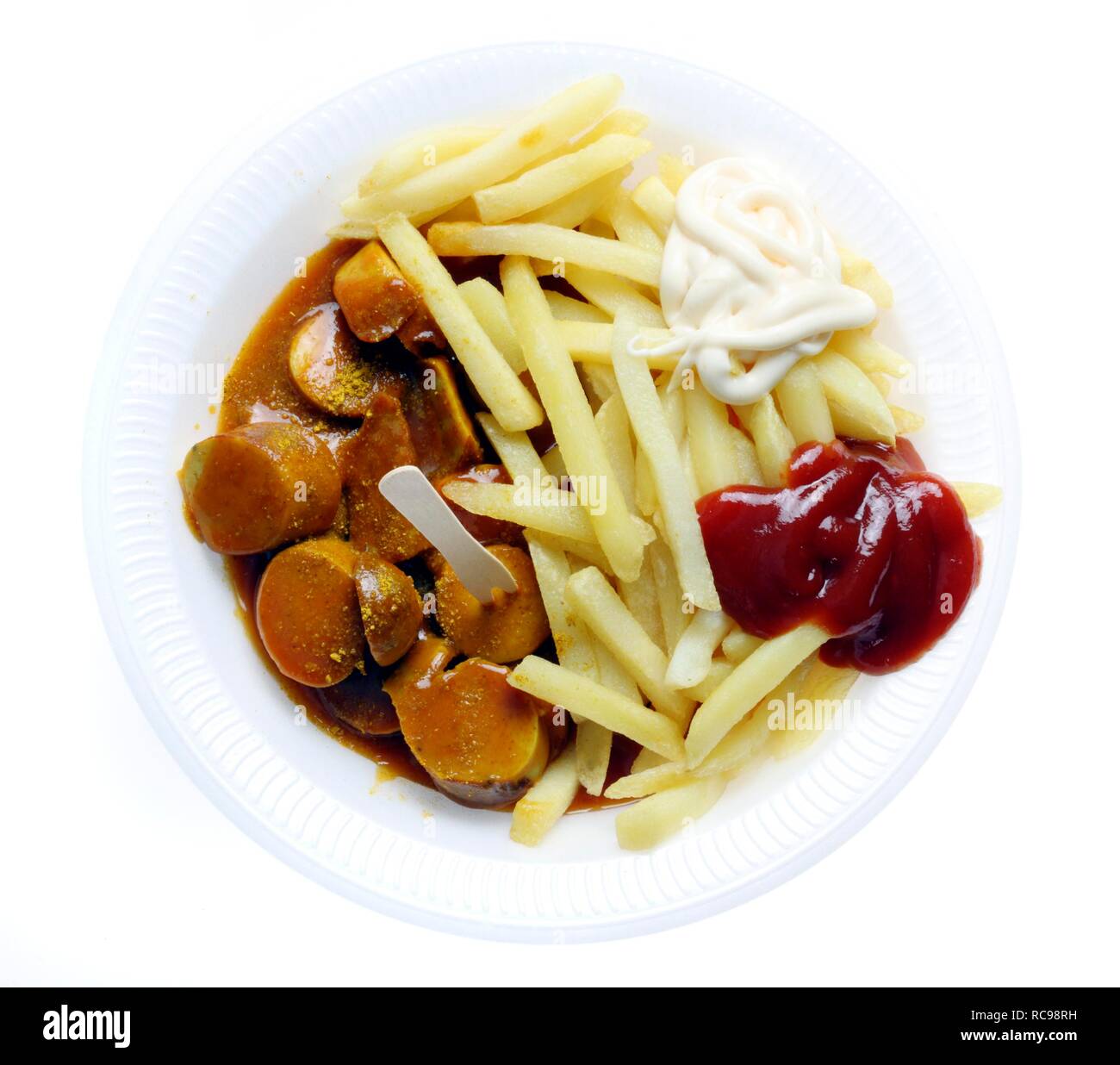 Il fast food, patatine fritte e salsiccia con il curry in polvere su di un piatto di carta con ketchup e maionese Foto Stock