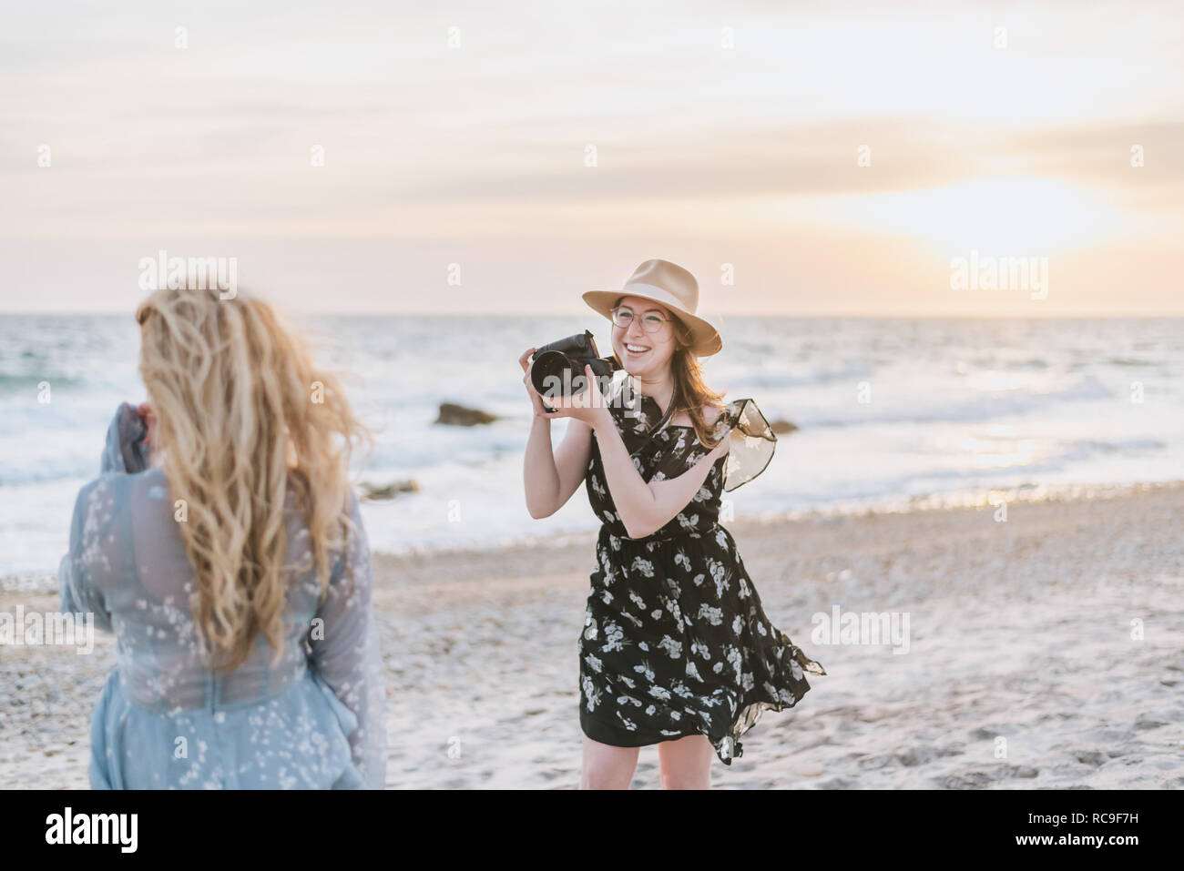 Giovane donna fotografare amico su windy beach, Menemsha, Martha's Vineyard, Massachusetts, STATI UNITI D'AMERICA Foto Stock